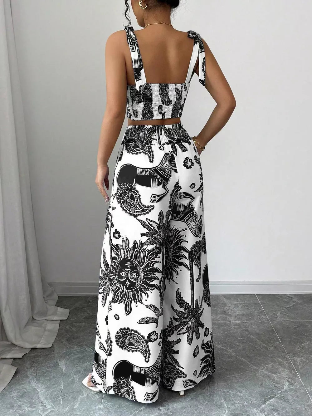 Black and white tropical print crop top and wide-leg pants set with tie straps.