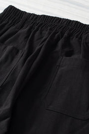 Black seamed front wide leg trousers with elastic waistband and patch pockets.