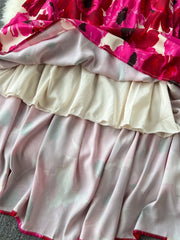Vibrant floral tiered cami dress with ruffled lining and pink trim.