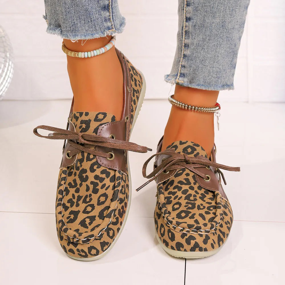 Leopard print boat shoes with leather accents and lace-up detail.
