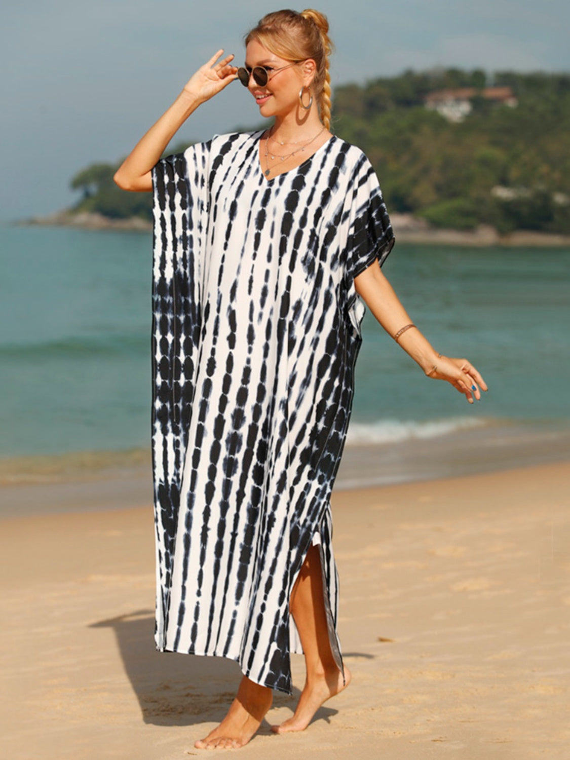 Black tie-dye maxi kaftan with vertical stripes and side slits, worn on the beach.