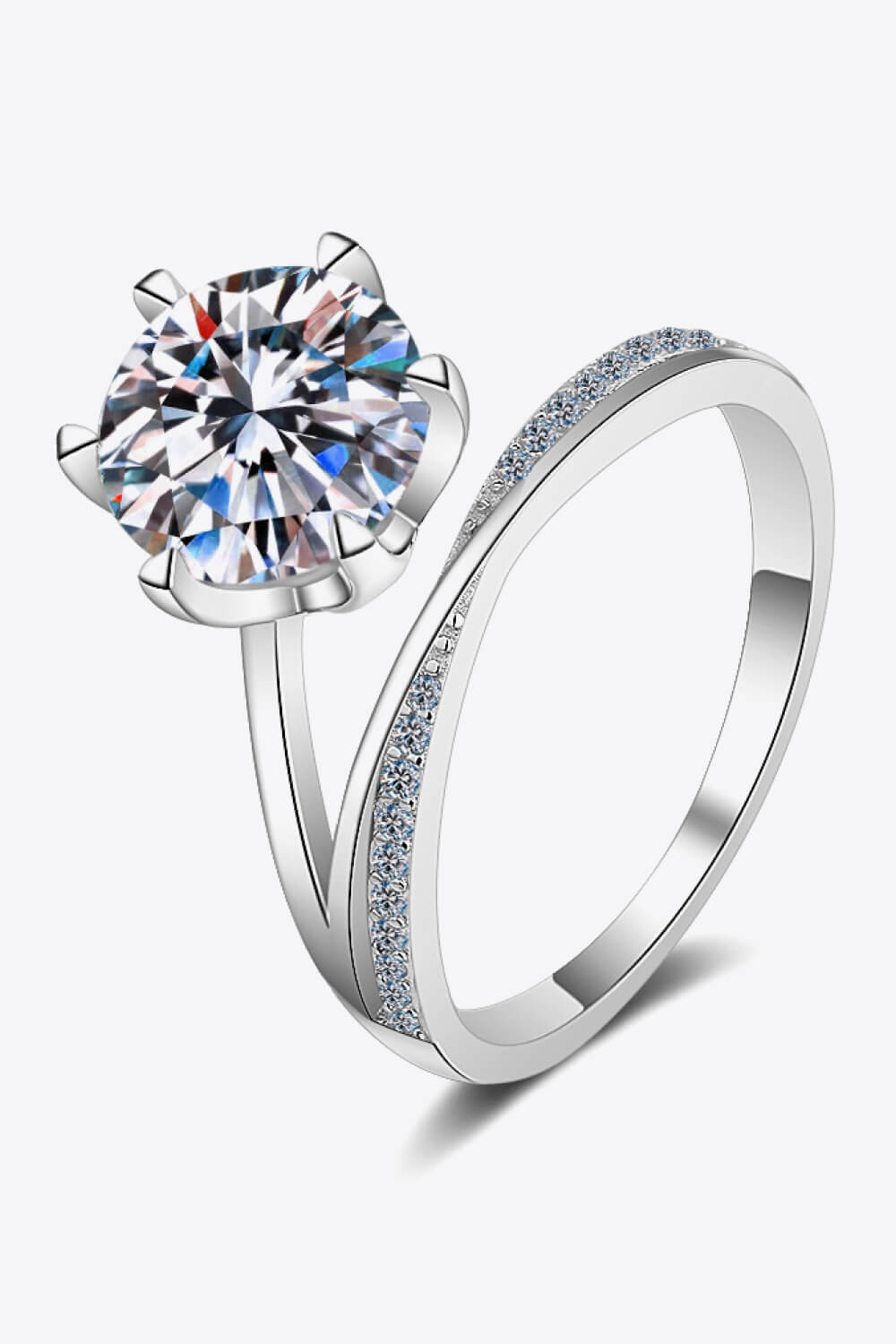 Silver bypass ring with large solitaire diamond and pavé band.