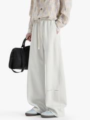 Casual wide-leg sweatpants in ivory with drawstring and subtle text detail.