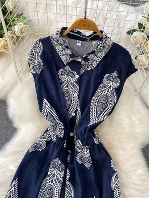 Navy blue collared button-down romper with white paisley print and drawstring waist.