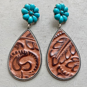 Tooled leather teardrop earrings with turquoise flower tops in brown and sky blue.
