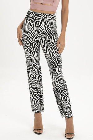 Zebra print flared leg trousers with a high waist, styled with heels.
