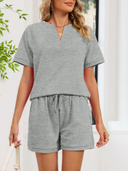 Gray two-piece loungewear set with drawstring shorts and a notched V-neck top.