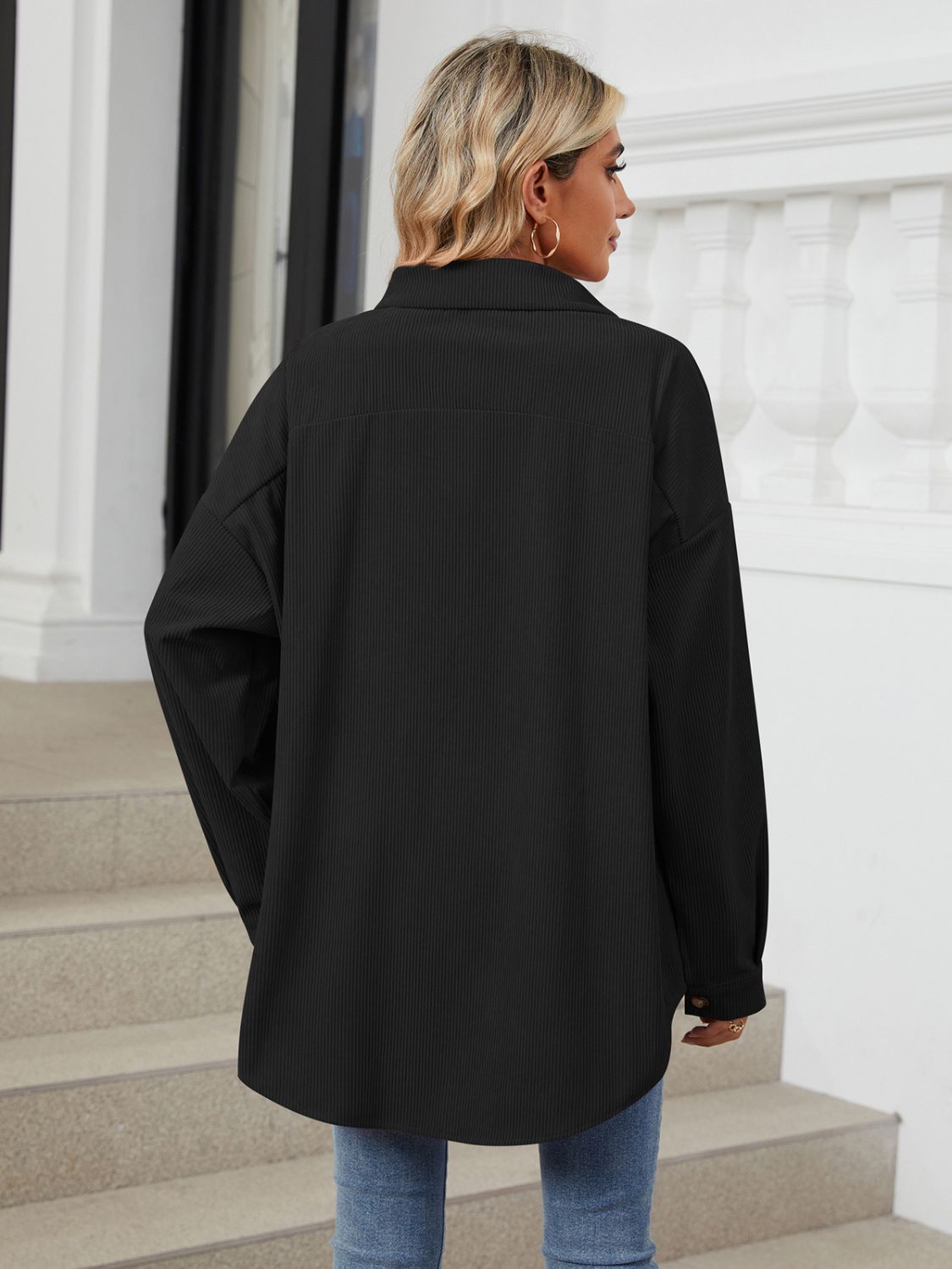 Black oversized corduroy shirt jacket with buttoned cuffs and a collar.