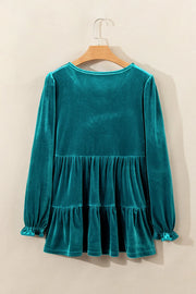Turquoise velvet tiered blouse with puffed sleeves and ruffled cuffs.
