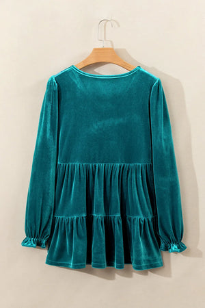 Turquoise velvet tiered blouse with puffed sleeves and ruffled cuffs.