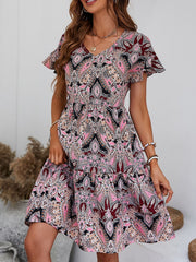 Paisley print mini dress with flutter sleeves and tiered skirt in pink, black, and cream.
