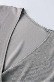 Gray Dawn ribbed knit wrap-effect blouse with V-neck detail.