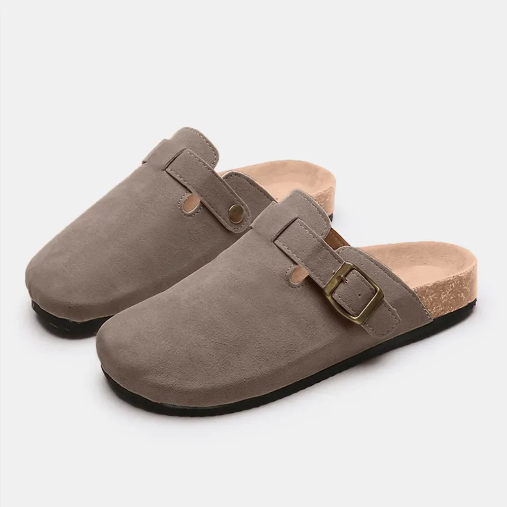 Suede clog slides in beige with adjustable buckle and cork sole.