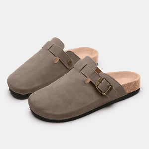Suede clog slides in beige with adjustable buckle and cork sole.