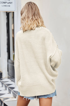 Oversized cream knit V-neck sweater with slouchy fit and ribbed hem.