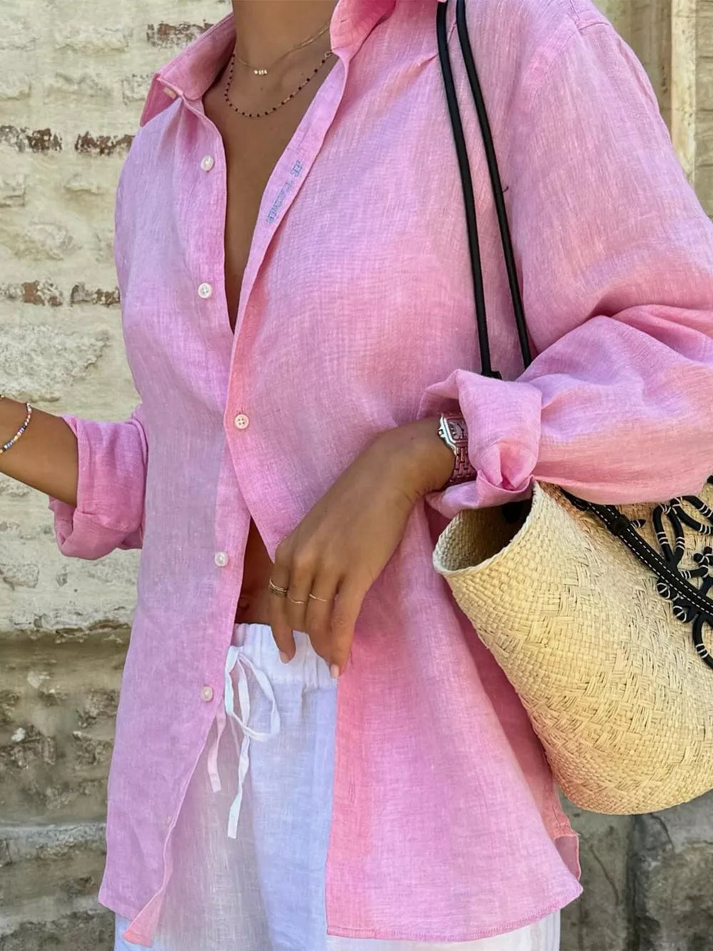 Pink cotton oversized button-up shirt with rolled sleeves, worn open over white drawstring pants.
