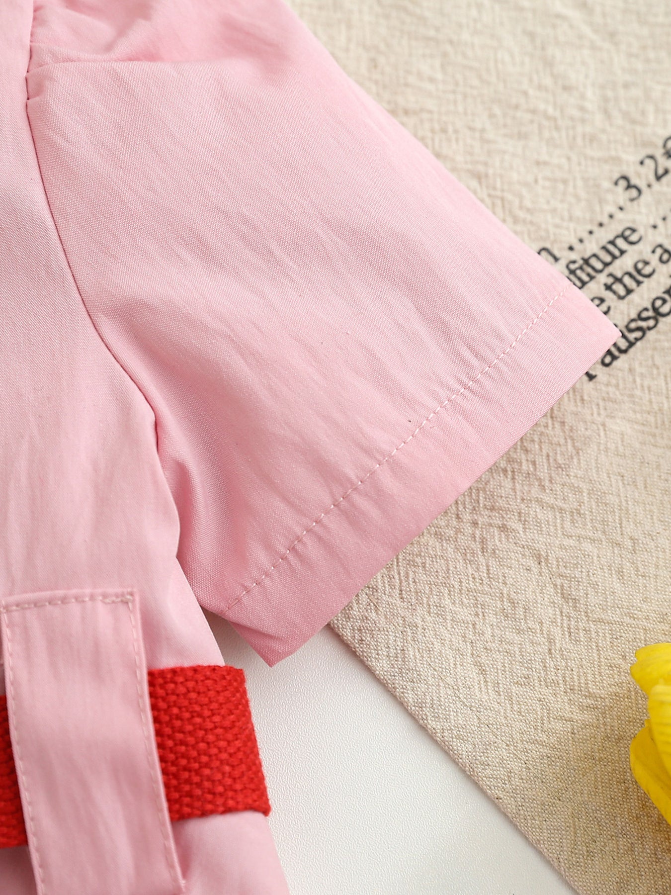 Pink cotton blend baseball dress for kids with red adjustable belt detail.