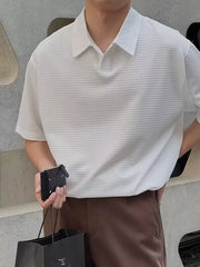 Men's white textured waffle knit polo shirt with button collar and short sleeves.