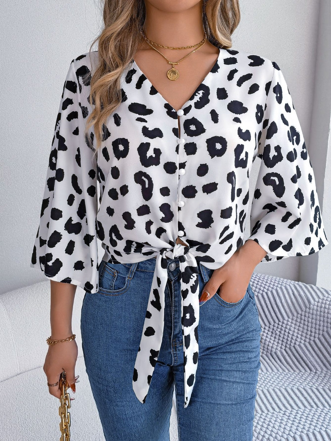 Leopard print tie-front blouse with button detail and bell sleeves.