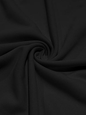 Black cotton t-shirt fabric with a subtle texture, shown in a draped swirl.
