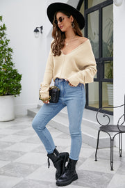 Caramel fluffy knit sweater with plunging neckline and long sleeves, styled with jeans.