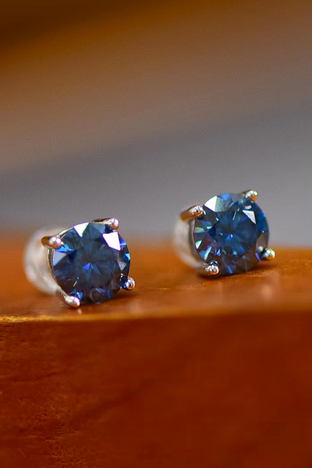 Sapphire stud earrings in platinum with clear backs, showcasing brilliant blue stones.