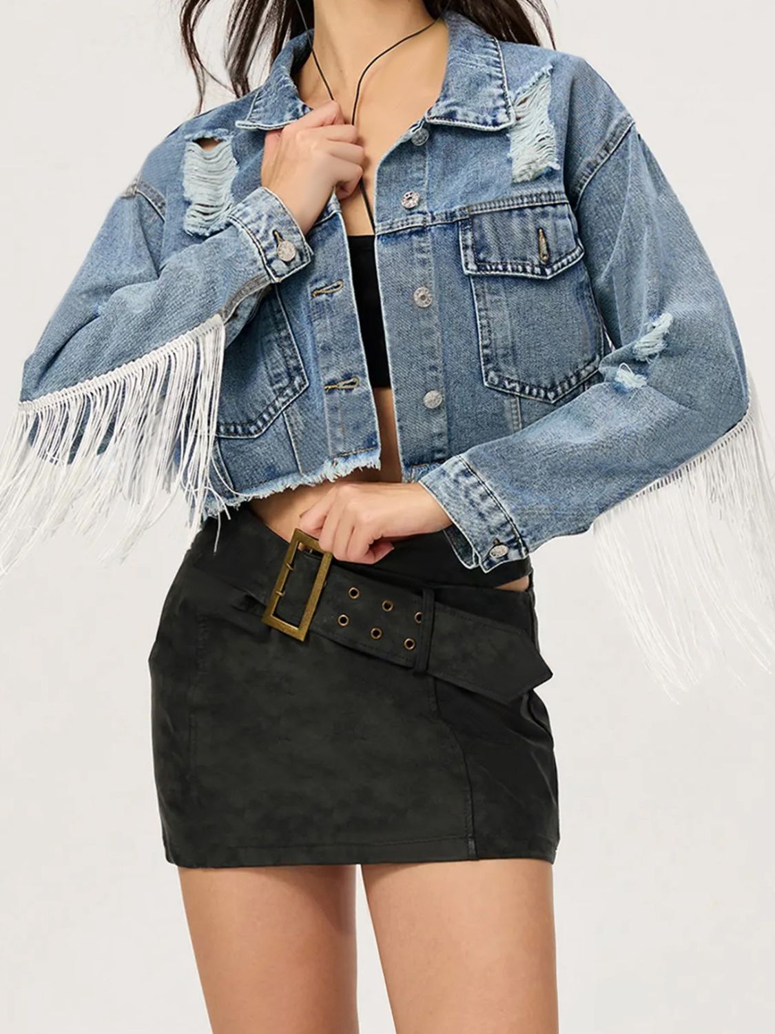 Distressed denim trucker jacket with fringe trim and frayed hem.