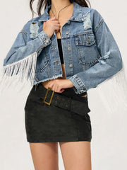 Distressed denim trucker jacket with fringe trim and frayed hem.