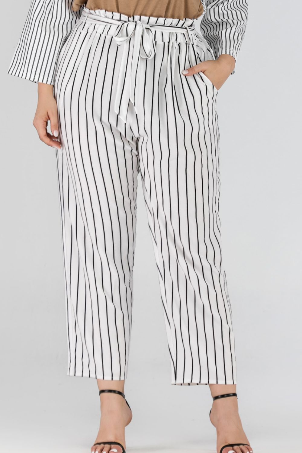 White vertical stripe paperbag waist trousers with tie belt and pockets.