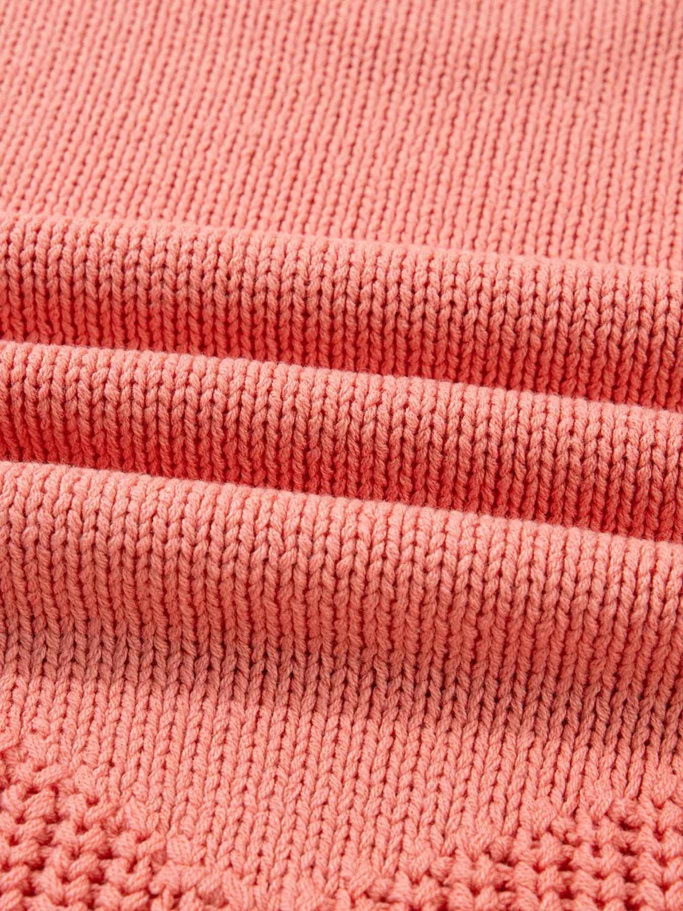 Burnt coral knit sweater with detailed texture and subtle open knit pattern.