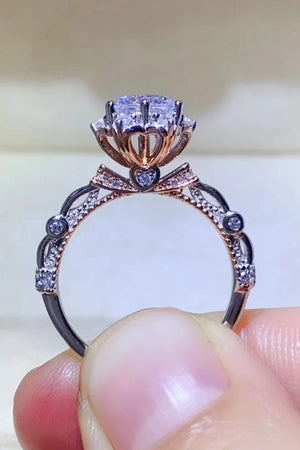 Sterling silver moissanite halo ring with bow detail and pavé accents.