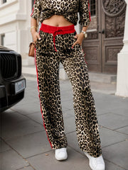 Leopard print lounge pants with red stripe detail and drawstring waist.