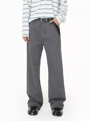 Men's relaxed fit grey cotton jeans with button closure and braided belt.