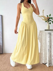 Yellow V-neck ruched maxi dress with empire waist and halter neckline.