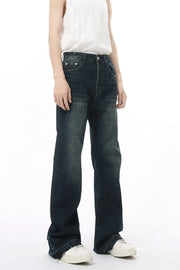 Dark wash flared jeans with vintage fading and distressed hem.