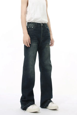 Dark wash flared jeans with vintage fading and distressed hem.