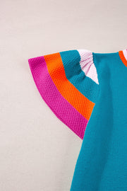 Teal knit blouse with flutter sleeves and colorblock trim in pink, orange, and teal.