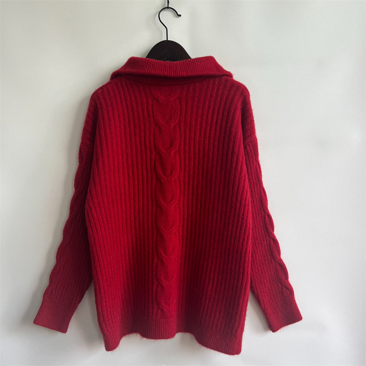 Red cable knit zip-neck sweater with ribbed texture and prominent cable detail on back.