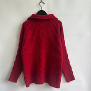 Red cable knit zip-neck sweater with ribbed texture and prominent cable detail on back.