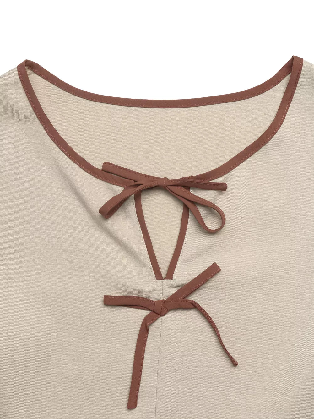 Charming V-neck blouse in beige with brown trim and tie details.