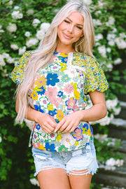 Floral patchwork puff sleeve blouse with crochet trim and mixed floral prints.