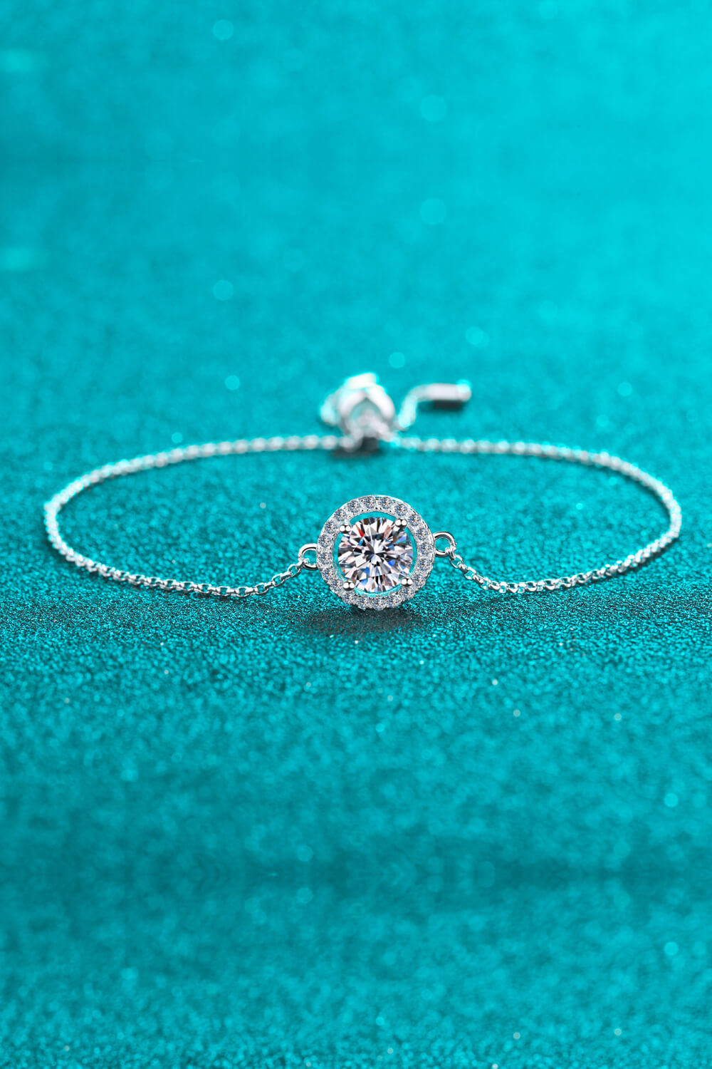Silver halo moissanite adjustable bracelet with a sparkling round center stone.