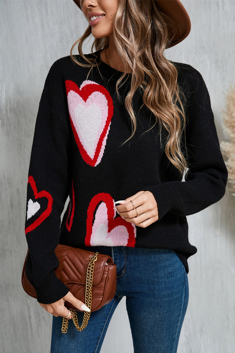 Black intarsia knit sweater with heart motif, crew neck, long sleeves.