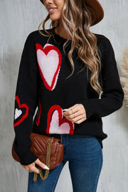 Black intarsia knit sweater with heart motif, crew neck, long sleeves.