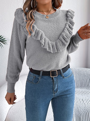 Gray knit sweater with textured yoke and ruffled detail.
