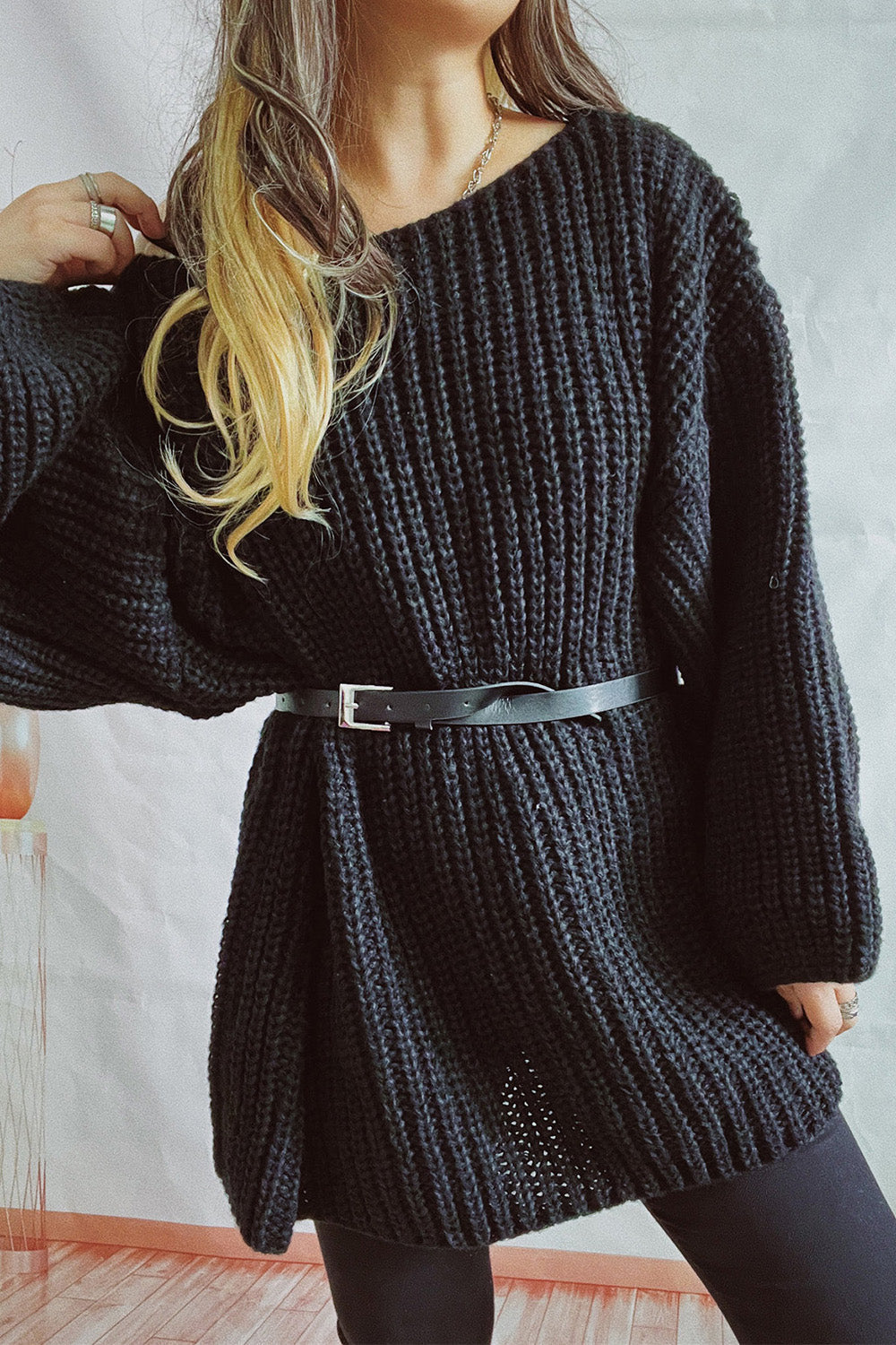 Black ribbed knit belted mini dress with boat neckline and long sleeves.