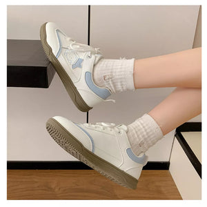 White and blue lace-up sneakers with cartoon accents and brown soles.