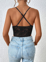 Black lace bodysuit with crisscross straps and a keyhole detail, styled with jeans.