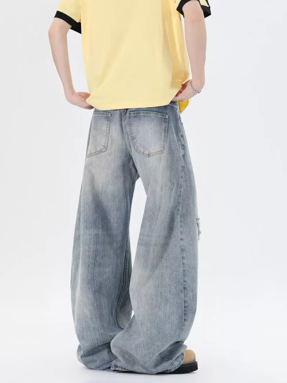 Men's light wash distressed wide-leg jeans, 100% cotton, relaxed fit.