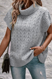 Gray cable knit turtleneck capelet sweater with short sleeves.